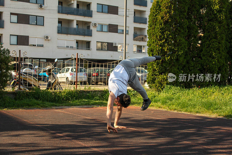 White man doing a handstand in a public park